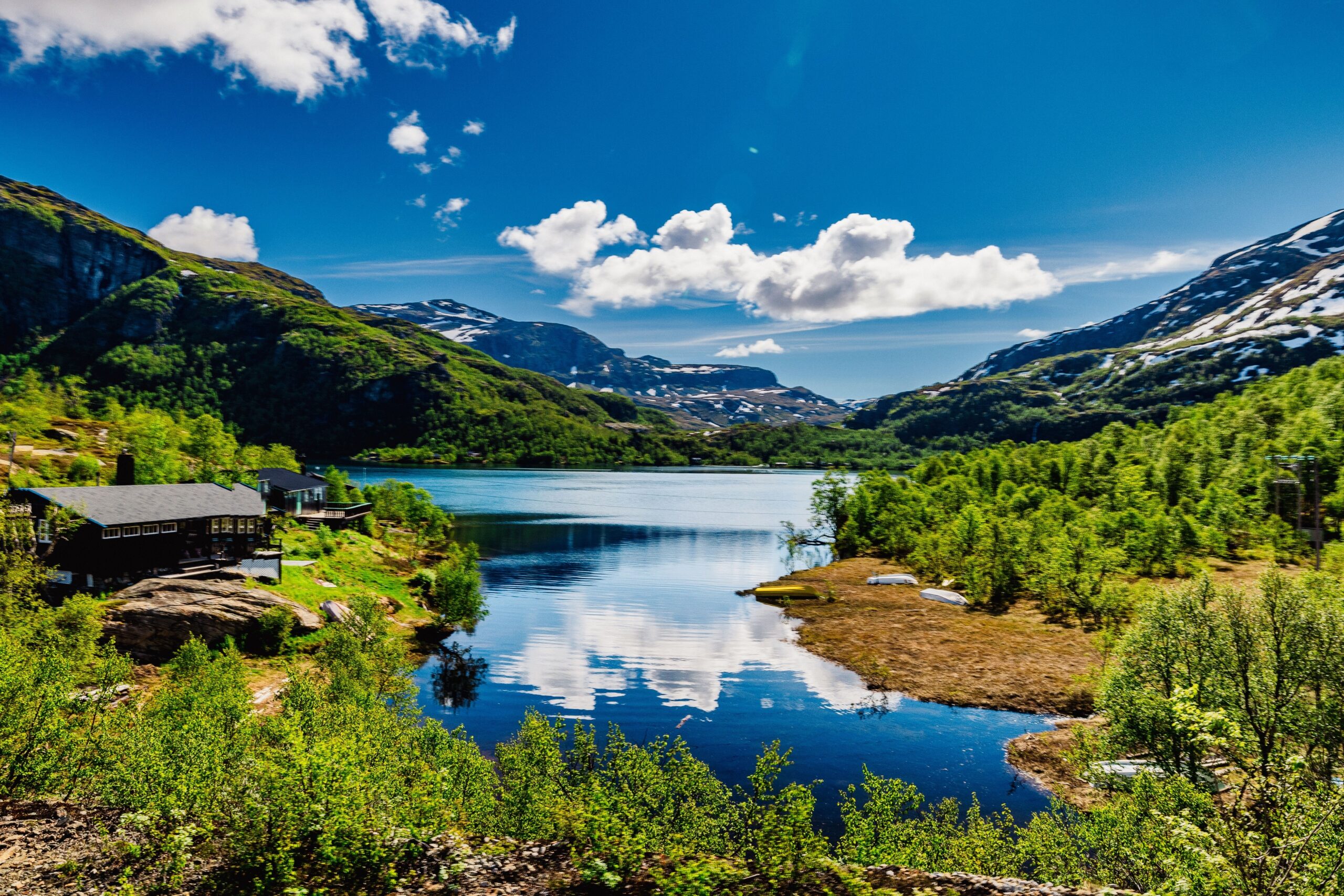 Scenic,View,Of,A,Lake,Surrounded,By,Mountains,And,Greenery